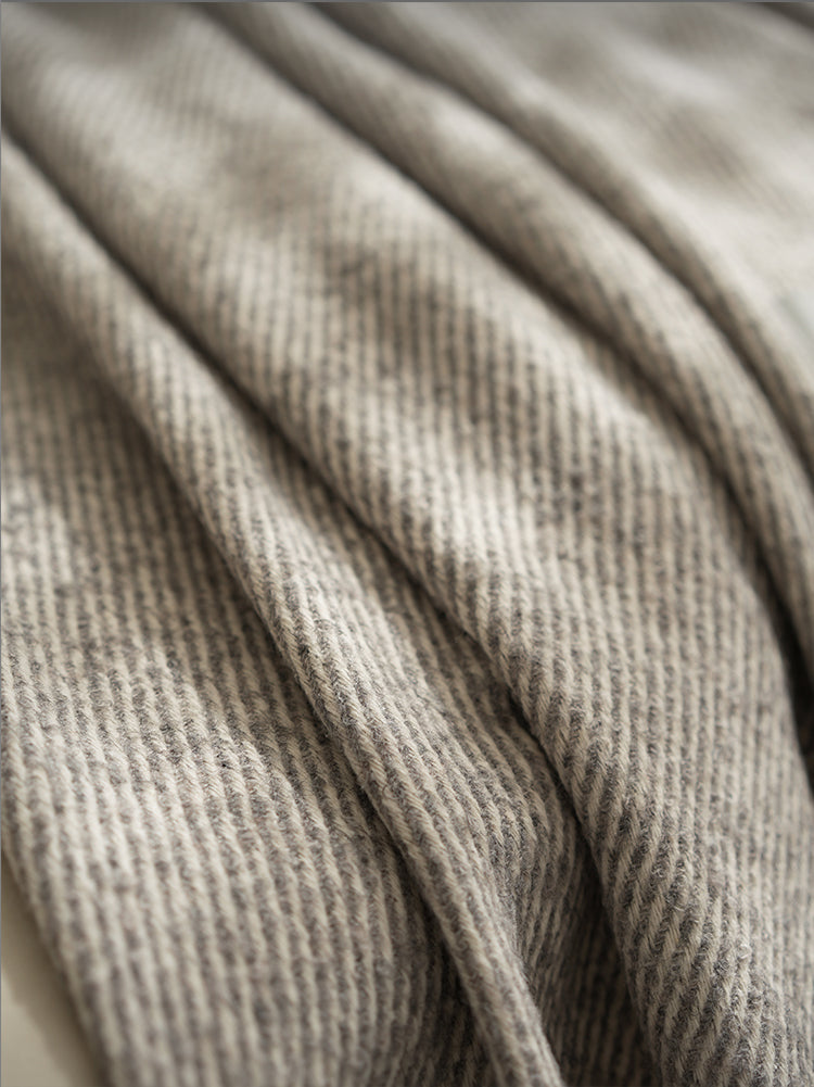 Close-up van een grijze beige plaid met een fijn geweven patroon, met subtiele textuurdetails voor een luxe uitstraling