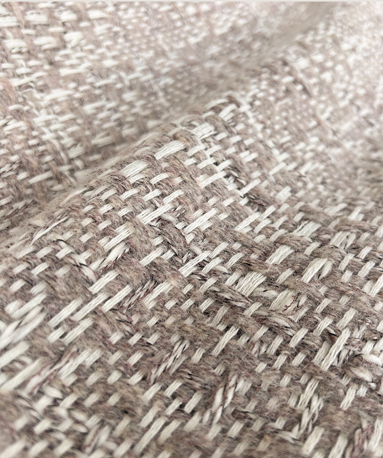 Detailopname van het jacquard geweven patroon van de NOLA alpaca wollen plaid in camelkleur, met zichtbare textuur van alpaca en wol